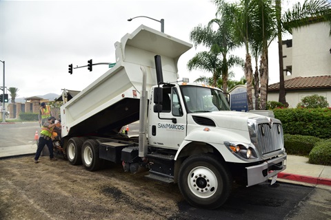 Dump truck pouring asphalt.