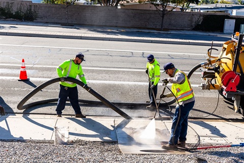 Maintenance workers cleaning out storm drain.