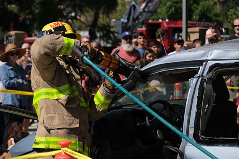 Firefighter using a cutting tool on car.